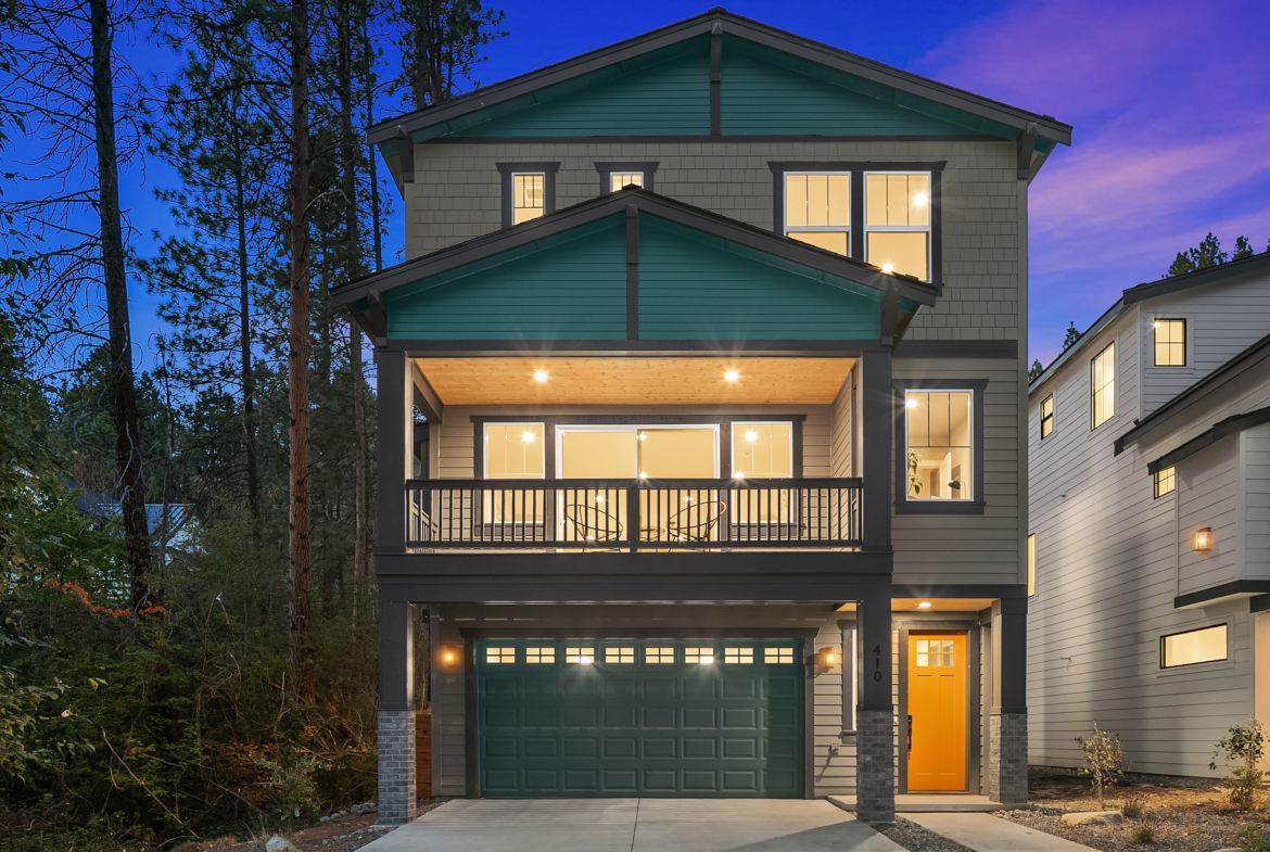 three story home in Cle Elum by Trailside Homes with green gables and taken at night