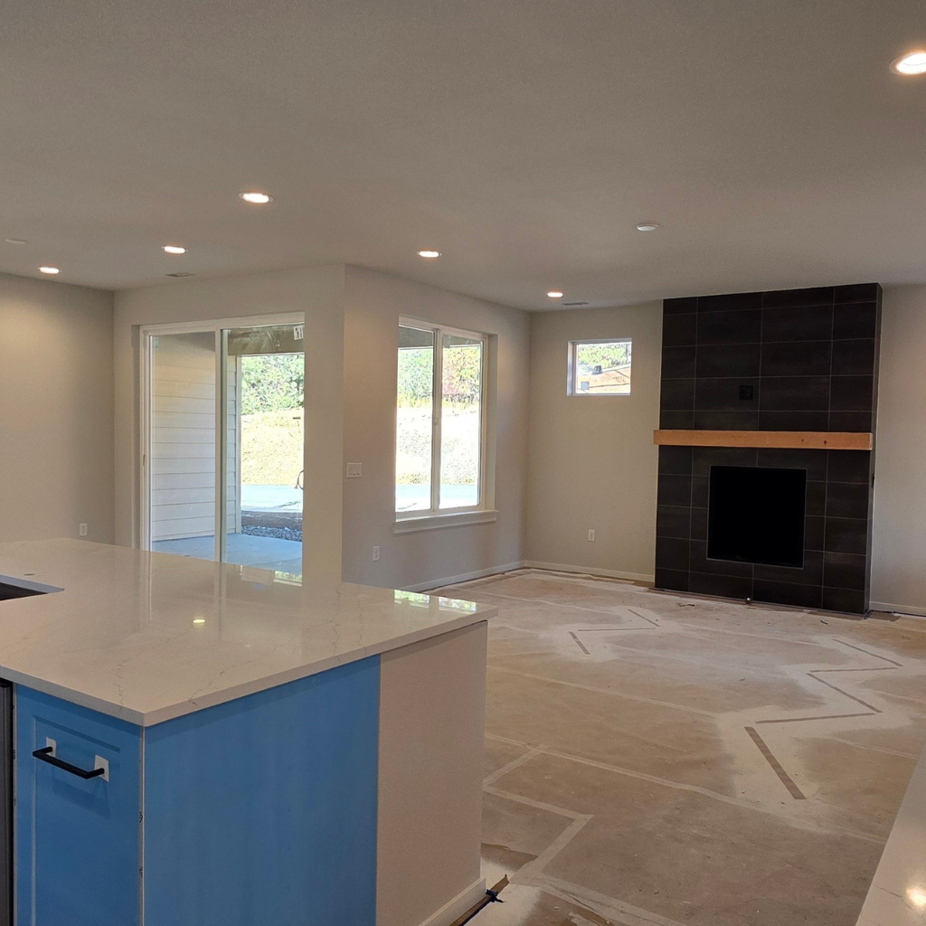 Ederra homesite 21 living room with fireplace and kitchen island view while under construction