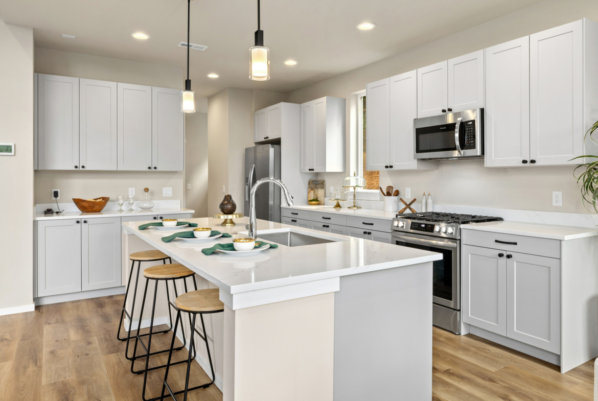 The view of the kitchen in teh Ederra 6 kitchen with light cabinets and a fridge
