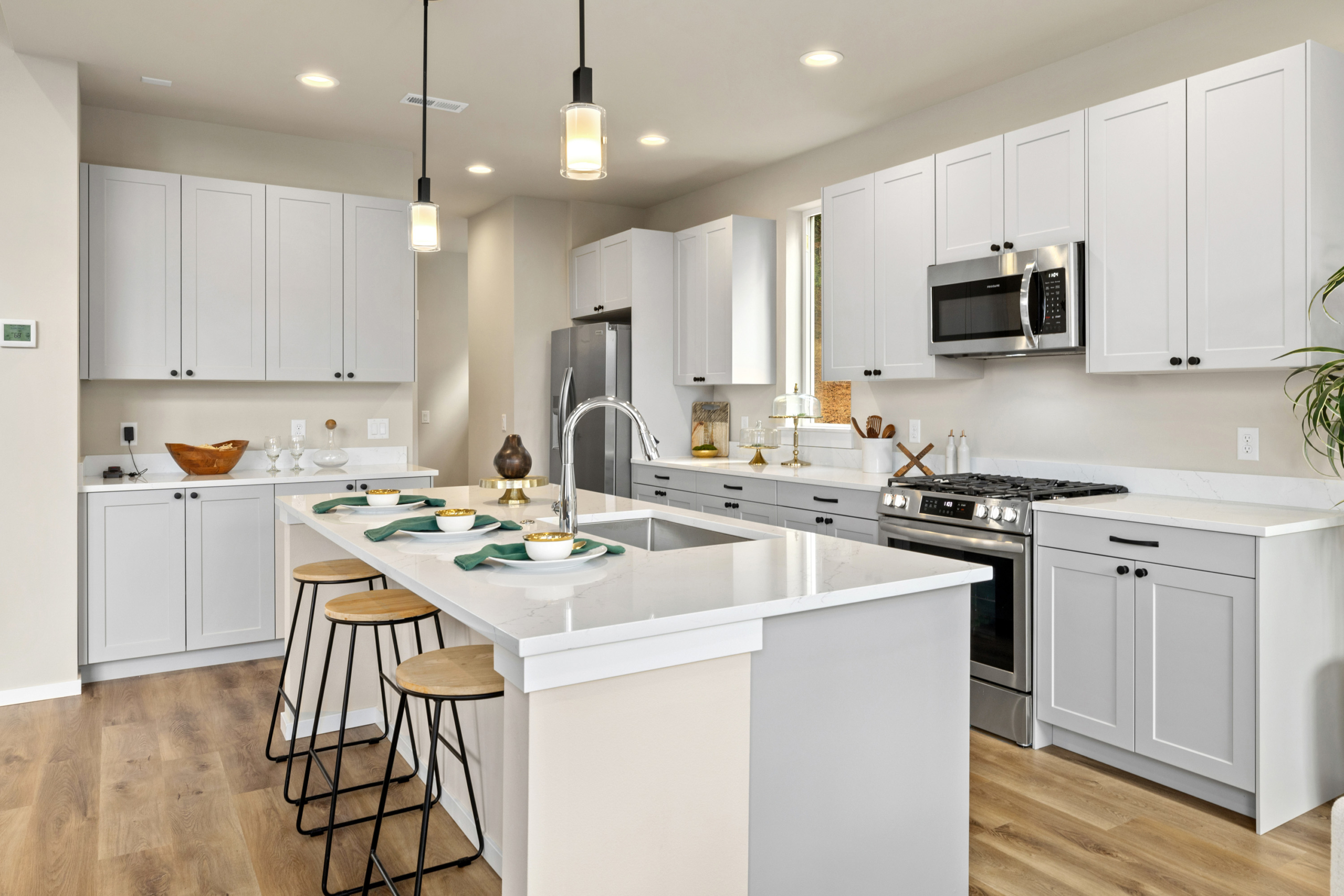 The view of the kitchen in teh Ederra 6 kitchen with light cabinets and a fridge