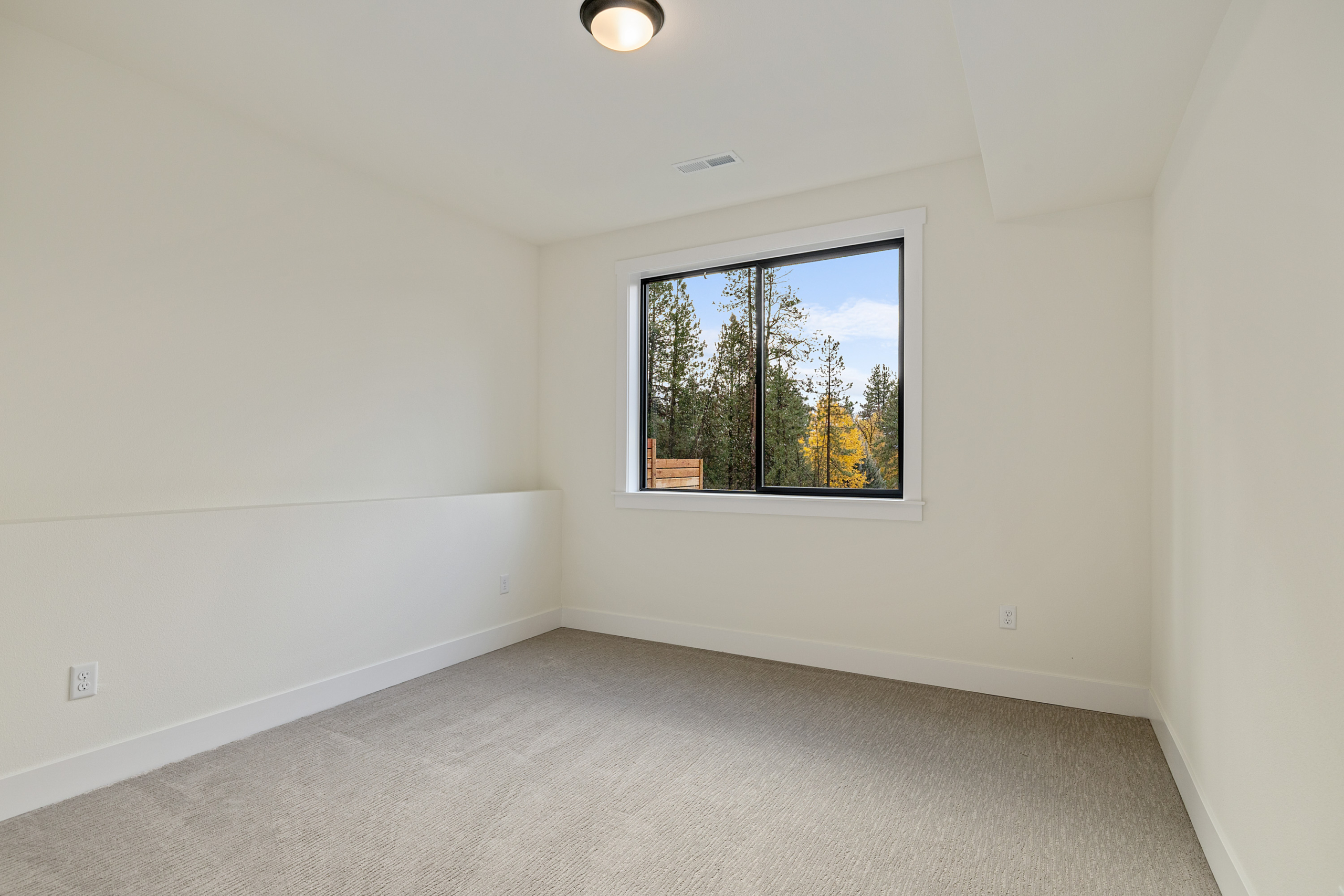 Ederra Lot 7 The Naches in Cle Elum by Trailside Homes downstairs bedroom with a view of trees