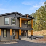 The Thorp at Ederra in Cle Elum by Trailside Homes front elevation with stained posts and grey paint with dark stone accents