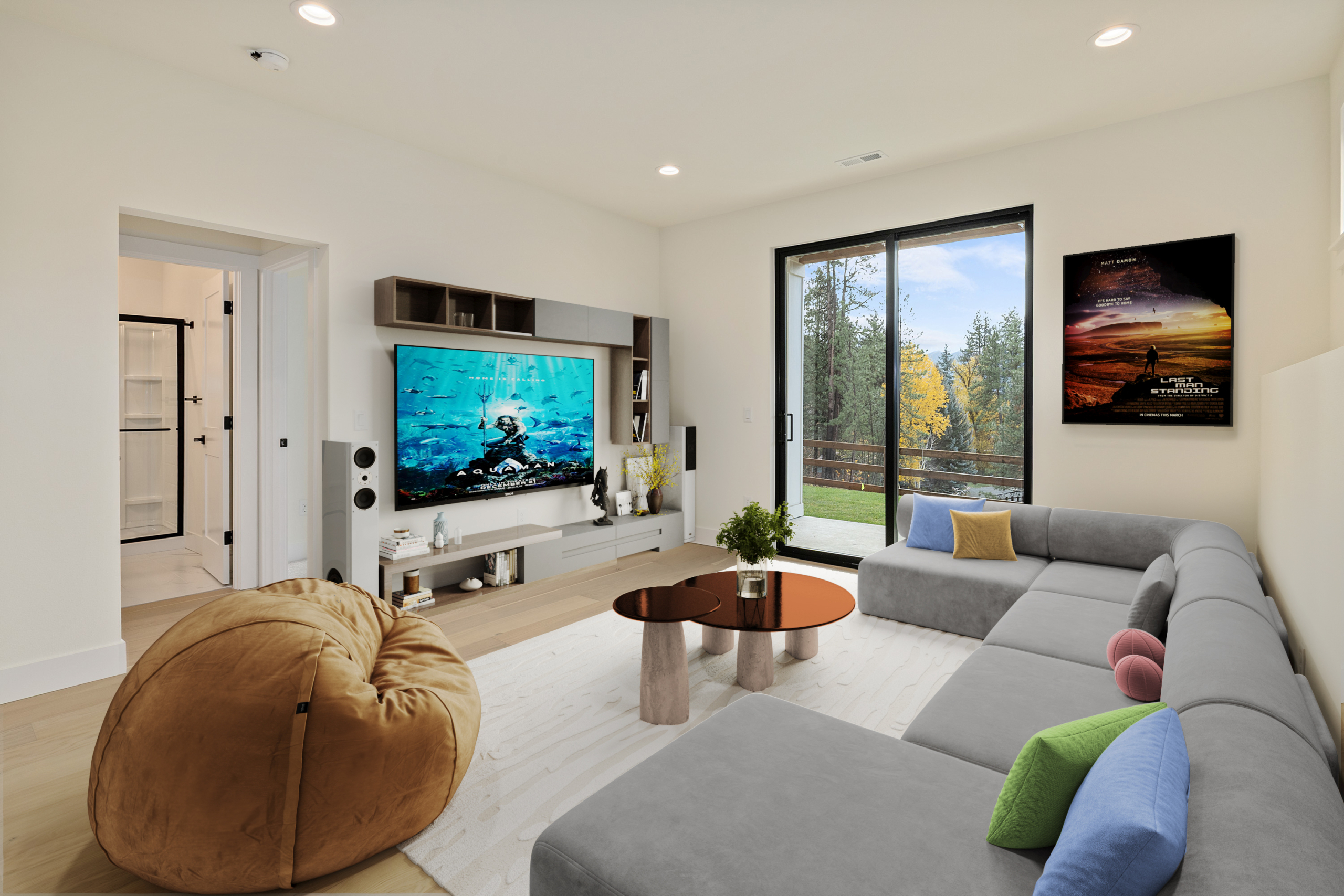 The Naches rec room decorated as a movie room with a grey couch and a leather bean bag chair