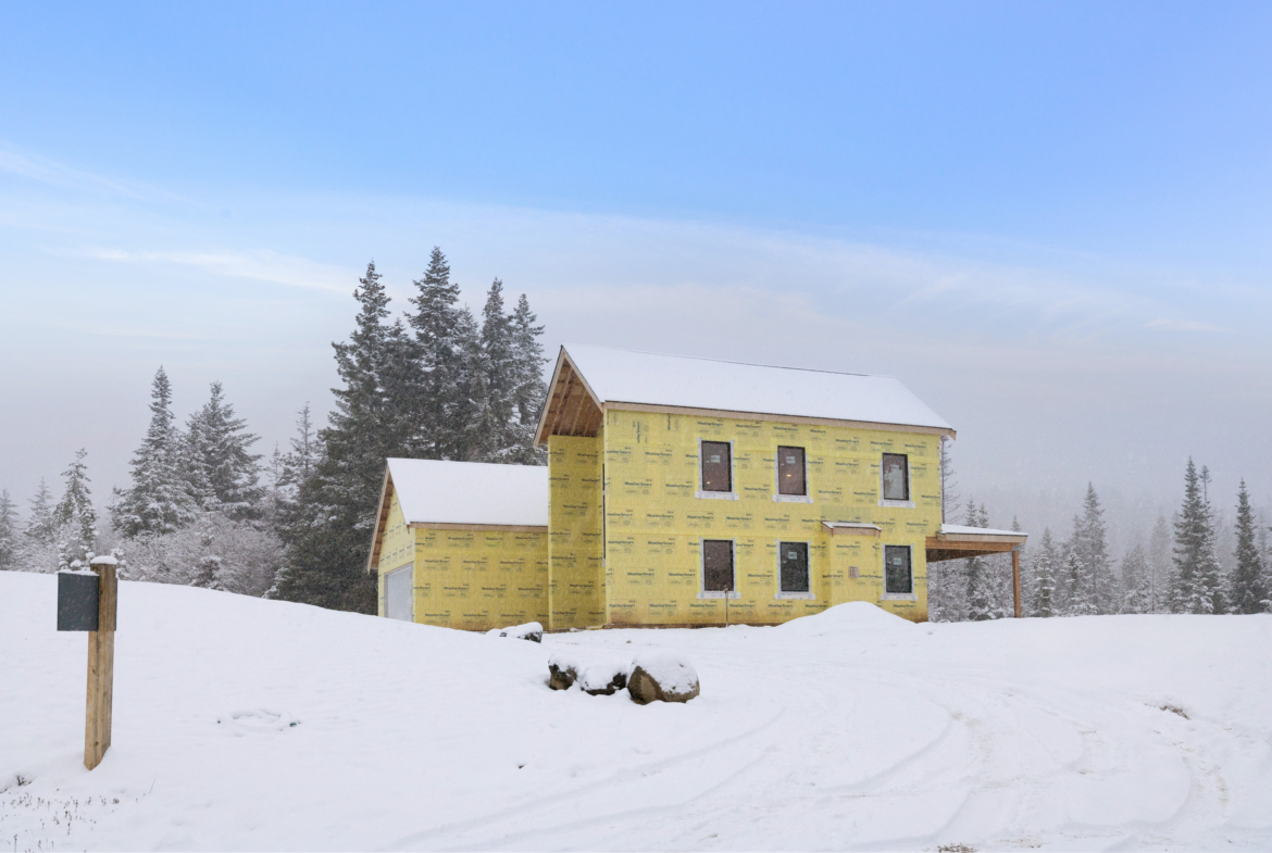 Skyline Ridge homesite 55 progress photo side view of the exterior covered in snow