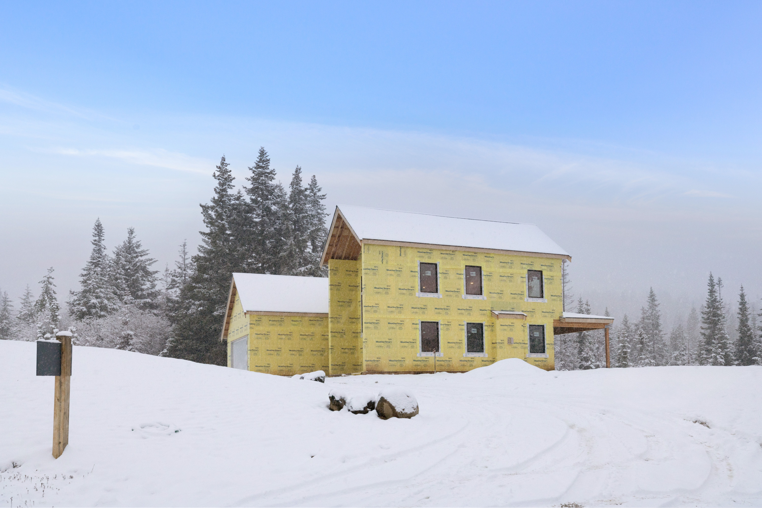 Skyline Ridge homesite 55 progress photo side view of the exterior covered in snow