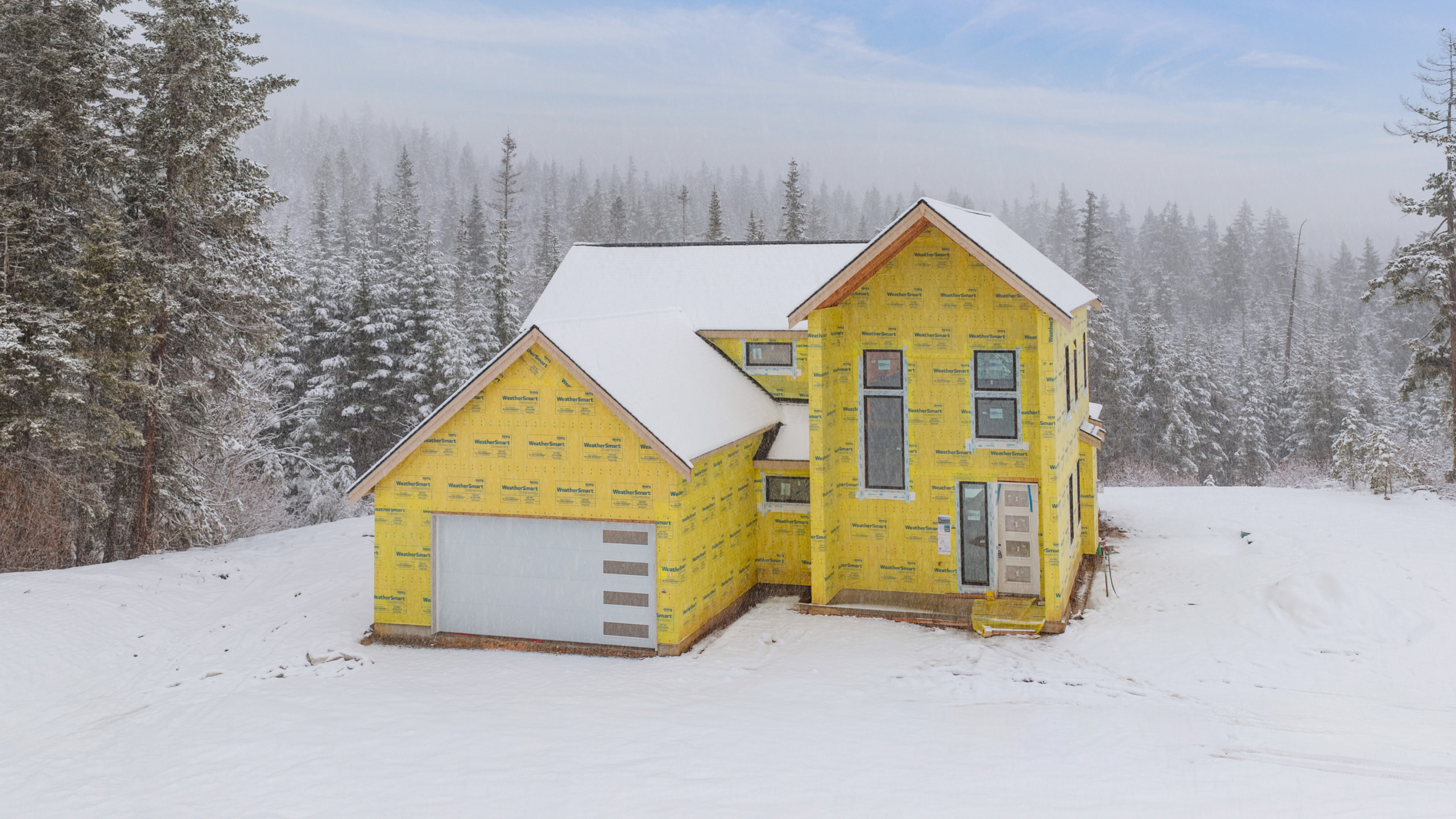 Skyline Ridge homesite 55 progress photo front exterior of the home covered in snow